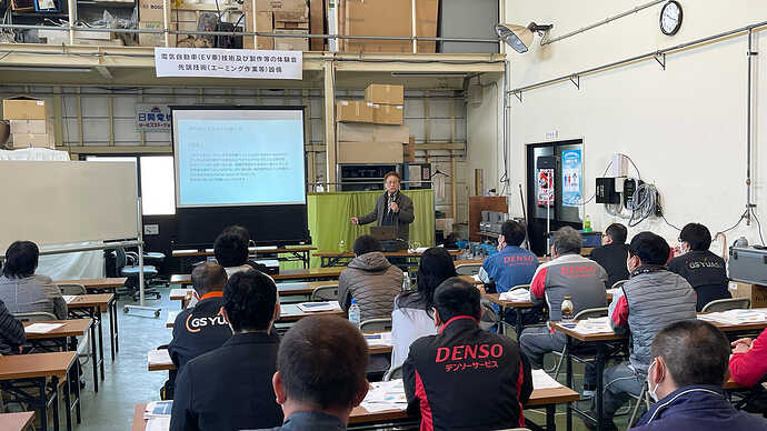 シャッターを閉めた整備工場に机を並べて講習会。話しているのは舘内さんです。