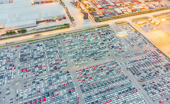 Logistics and transportation of Container Cargo ship and Cargo import/export and business logistics,Aerial view from drone top view new cars lined up in the port for import and export.