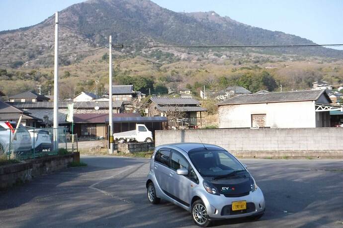 店舗周辺はのどかな風景。写真のi-MiEVは筆者のマイカー、後ろの山は「紫峰」の別名がある「筑波山」です。