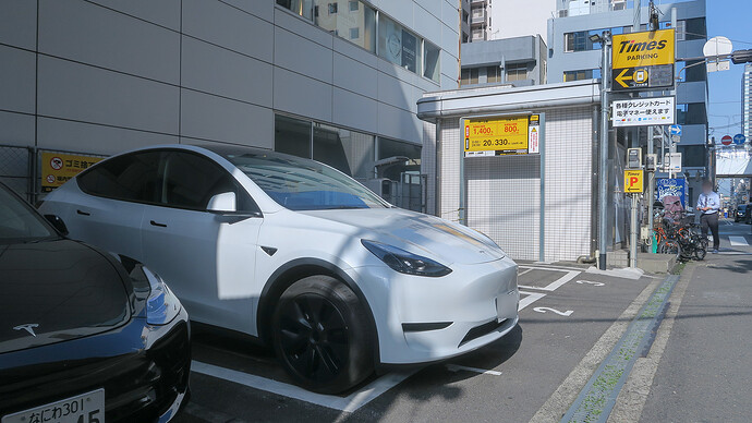 利用前日、南森町に着いてステーションの場所を確認。右に人が立っている交差点が地下鉄駅の入り口。ホテルも歩いて20秒くらいの好立地でした。隣に白いモデルYが停まっていて「これもシェアカー？」と思ったら、普通にコインパーキングを利用している一般車両でした。