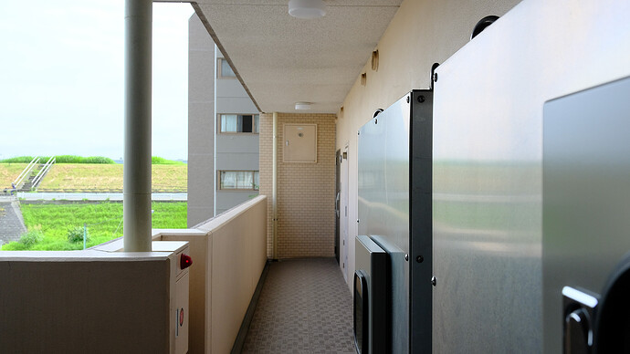 非常用電源装置の一部（画面右の銀色の箱2つ）と、近くを流れる荒川堤防の最上面が見える。3階だと堤防最高地点を超えた水流より少し上に位置することになる。