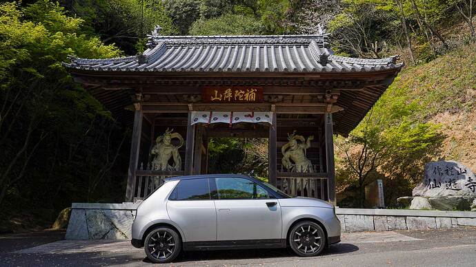 58番 仙遊寺の境内は標高300mの作札山の山頂近くにある。Honda e の走りが頼もしい急坂を登る途中に山門がある。フロントドア前方上部の黒いバー状のものがサイドカメラでLEDウィンカーを備える。