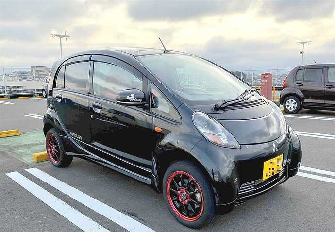 10年目を迎えたKAKUさんのi-MiEV M。ピカピカに磨かれて、色々なところに手が入っている。ボディー側面下部のラインやロゴが手作りなだけでなく、リアカメラを介してバックミラーに後方映像が投影されるミラーモニターもご自分で装着。