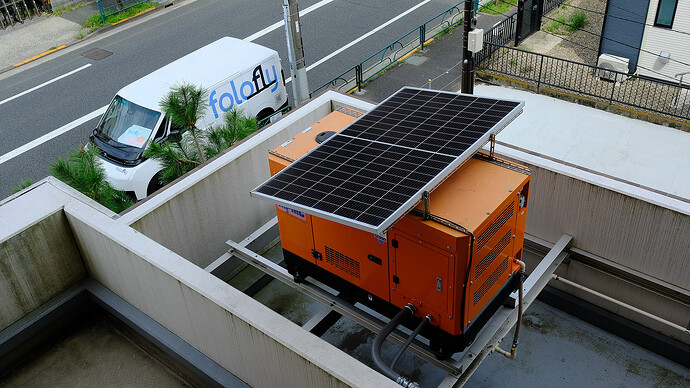 3階部分の屋外に設置された非常用ガス発電機。上に日差し除けを兼ねた太陽光パネルが少しだけ載せられている。メインの太陽光パネルはマンション屋上に別に設置されている。