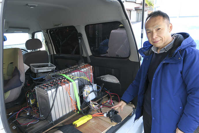 健康診断をお願いしたオズコーポレーションの古川氏。バンの荷室に搭載されているのは、改造EV用にリーフの中古電池を組んだチャデモ適合確認システム。