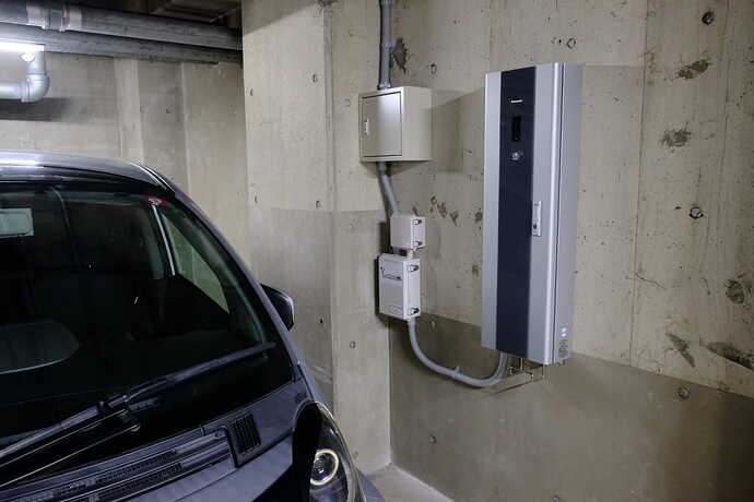 灰色と黒の細長いボックスが今回設置された普通充電器。その左隣りにあるのは課金システムを動かす通信機器などのボックス。